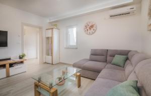 ein Wohnzimmer mit einer Couch und einem Glastisch in der Unterkunft Apartment Štefa in Krk