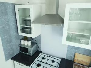 a small kitchen with a stove and a microwave at Apartment - Sleeps 5 & On-site Parking in Newport