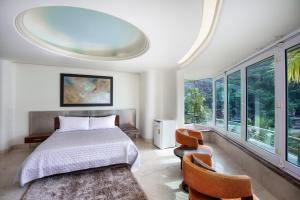 um quarto com uma cama e uma grande janela em Boca de Tomatlán Ocean Frontage Boutique Hotel em Puerto Vallarta