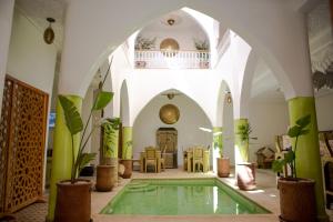 Habitación con piscina en medio de un edificio en Riad Petite Rose en Marrakech