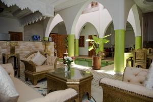 sala de estar con sillas, mesa y chimenea en Riad Petite Rose, en Marrakech
