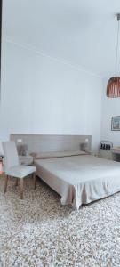 a bedroom with a large bed and a chair at Il Quadrifoglio Room& Suite in Palermo