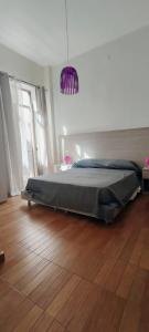 1 dormitorio con 1 cama y suelo de madera en Il Quadrifoglio Room& Suite, en Palermo