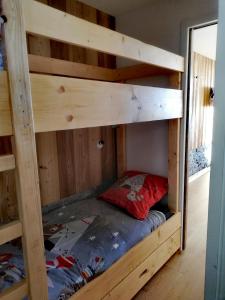 a bunk bed in a cabin with a red pillow on the bottom bunk at Studio Pour 4 Personnes in Chamrousse