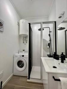 a bathroom with a washing machine and a sink at Apartamento muito central - 300 metros da Praia in Costa da Caparica