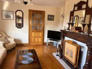a living room with a couch and a fireplace at Spacious Countryside 4BD House! in Cavan