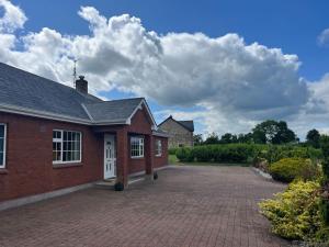 a red brick house with a brick driveway at Spacious Countryside 5BD House! in Cavan
