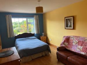 a bedroom with a bed and a couch and a window at Spacious Countryside 5BD House! in Cavan