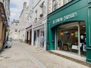 eine Straße mit einem grünen Laden an einer Stadtstraße in der Unterkunft La Maison Rose en Centre historique in Arras