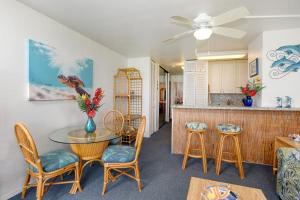 a living room with a table and chairs and a kitchen at Maalaea Banyans 113 in Maalaea