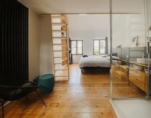 阿拉斯La Maison Rose Quartier des Arts - Hyper centre的一间卧室，里面有一张床和一面玻璃墙