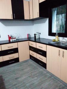 a kitchen with white cabinets and black counter tops at Villa magnifique avec piscine in Somone