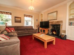 a living room with a couch and a fireplace at Gweek House in Helston