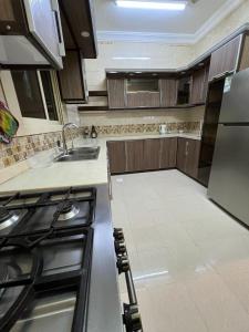 een keuken met een wastafel en een fornuis top oven bij Private Family's Apartment in Obhor