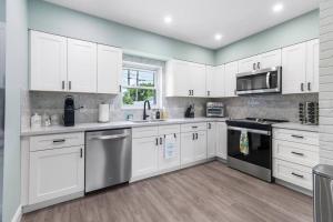 a kitchen with white cabinets and stainless steel appliances at Saltwater pool, FREE beach passes & GREAT location! in Boynton Beach