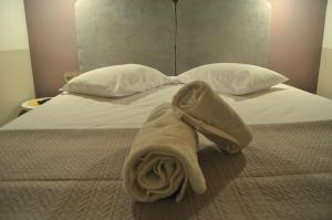 - un lit avec des oreillers blancs et une serviette dans l'établissement ΜΕΛΑΝΘΙΑ m5, à Prévéza