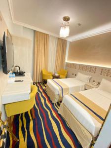 a hotel room with two beds and a television at Dar Al Naem Hotel in Al Madinah