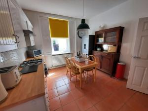 a kitchen with a table and chairs in a room at Anfield Haven in Liverpool