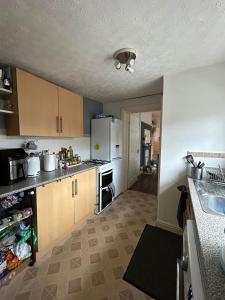 a kitchen with wooden cabinets and a counter top at Double room in Heaton in Heaton