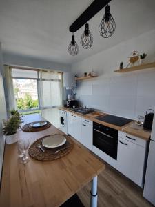 une cuisine avec une table en bois et une plaque de cuisson. dans l'établissement Appartement cosy à 100m de la mer, à Santa Pola