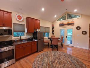 una cocina con armarios de madera y una mesa con sillas. en Poplar Treehouse - Rustic Luxury en Marshall