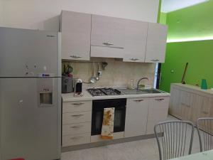 cocina con armarios blancos y fogones en Casa relax, en Vibo Valentia Marina