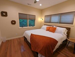 1 dormitorio con 1 cama grande y 2 ventanas en Poplar Treehouse - Rustic Luxury en Marshall