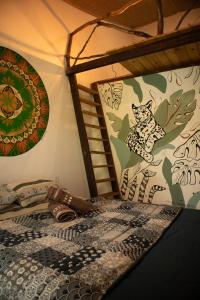 a bedroom with a bed with a painting of a cat on the wall at Espaço Cultural Lotus - Suítes, Hostel e Camping in Alto Paraíso de Goiás
