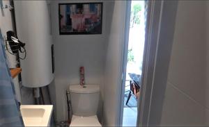 a bathroom with a toilet and a picture on the wall at studio cosy indépendant avec baie vitrée et jolie terrasse in Coulommiers