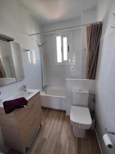La salle de bains est pourvue de toilettes, d'une baignoire et d'un lavabo. dans l'établissement Appartement cosy à 100m de la mer, à Santa Pola