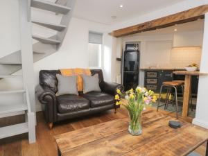 - un salon avec un canapé en cuir et une table dans l'établissement Cobble Cottage, à Kendal
