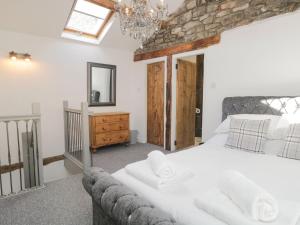 - une chambre avec un grand lit blanc et un miroir dans l'établissement Cobble Cottage, à Kendal