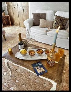 ein Wohnzimmer mit einem Tisch mit Essen und einer Kerze in der Unterkunft Appartement Un moment d’ÉVAsion in Épernay