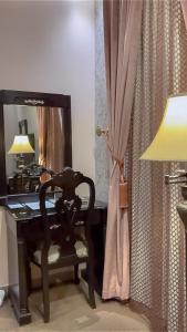 a desk with a chair and a lamp and a mirror at Levant Hotel in Najran