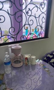 Casa Morada في برنال: طاولة زجاجية مع آلة صنع القهوة ونافذة