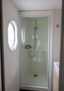 y baño con ducha de cristal y ventana. en Alojamiento - Bungalows en el centro de Laredo a 200 m de la playa en Laredo