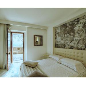 um quarto com uma cama com um quadro na parede em La Bastiglia em Spello