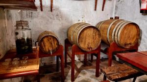 una habitación con 3 barriles de vino de madera en sillas en Los Nacientes: Cordero, en Los Sauces