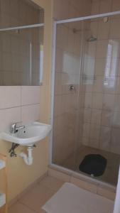 y baño con lavabo y ducha. en Steps Accommodation, en Gobabis