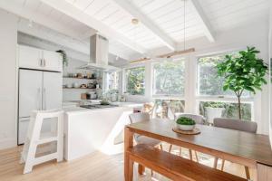 a kitchen with a wooden table and a kitchen with white cabinets at Charming Victorian Oasis with an Elegant and Spacious Haven in San Francisco