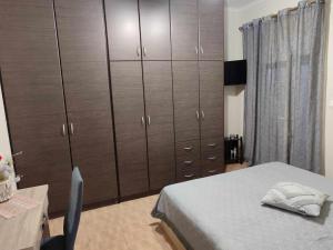 1 dormitorio con 1 cama y un gran armario de madera en Όμορφο διαμέρισμα σε μονοκατοικία στη Λεπτοκαρυα., en Leptokarya