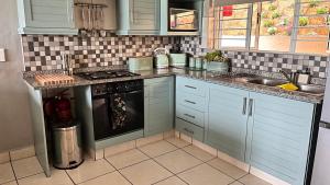 a kitchen with blue cabinets and a stove top oven at Cassa De La Luna Diossa in Kingsburgh