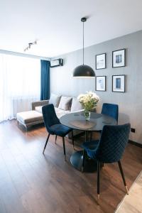sala de estar con mesa, sillas y sofá en Noche Apartamenty Premium, en Biała Podlaska