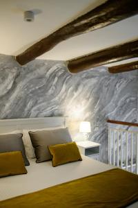 - une chambre avec un lit et un mur en marbre dans l'établissement Enjoy Naples, à Naples