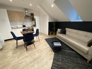 a living room with a couch and a table and a kitchen at Myaka©Appartement Boho in Cholet