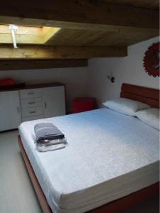 Una cama en un dormitorio con una maleta. en B&B L'Alba en Gagliato