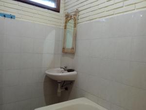 a bathroom with a sink and a toilet and a mirror at Pondok Bulan Mas in Ubud