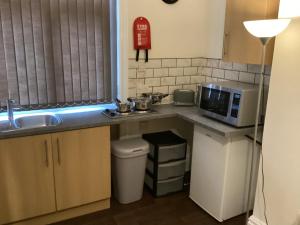a small kitchen with a sink and a microwave at Coventry Train station studio in Coventry