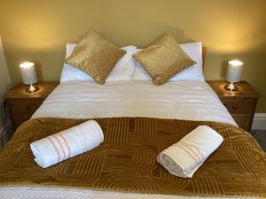 a large bed with two pillows and towels on it at Coventry Train station studio in Coventry