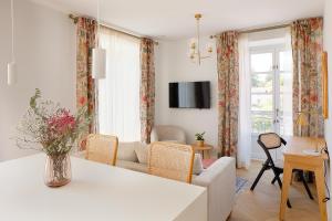 ein Wohnzimmer mit einem weißen Tisch und Stühlen in der Unterkunft Apartamentos La Colonia de Muros in Muros de Nalón